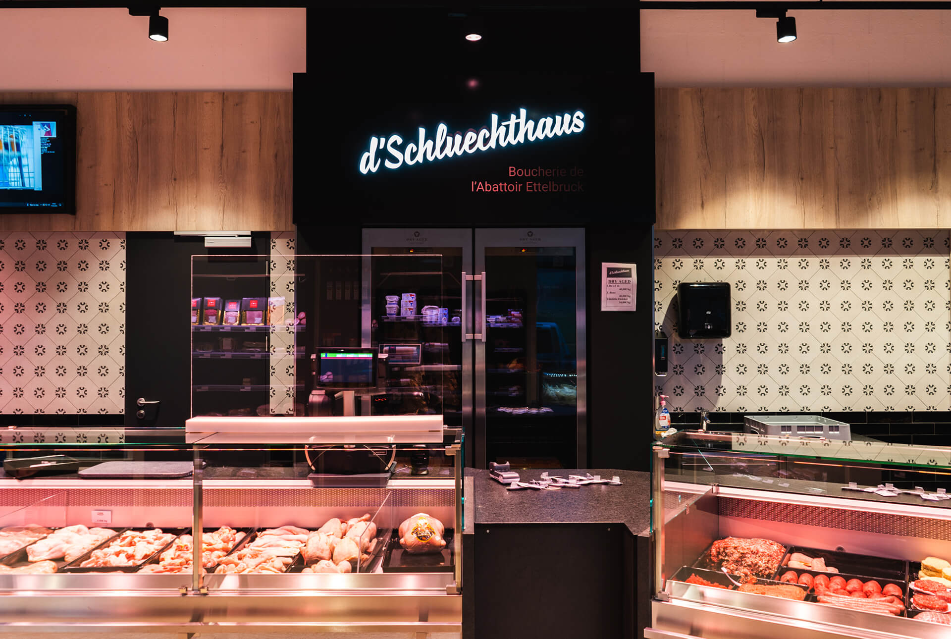 Intérieur des boucheries d’Schluechthaus avec une enseigne lumineuse portant le nom de l'établissement